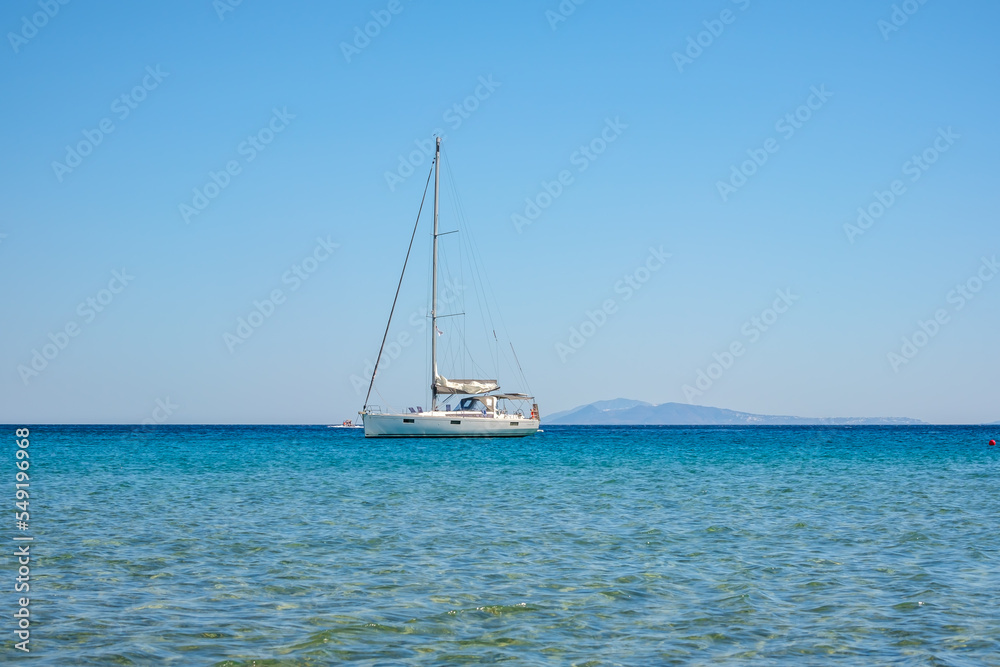 A sailboat at the famous  Mylopotas beach in Ios Greece