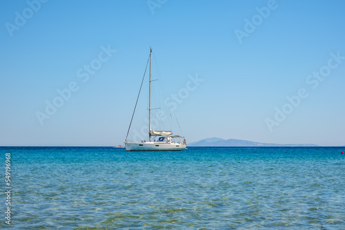 A sailboat at the famous Mylopotas beach in Ios Greece