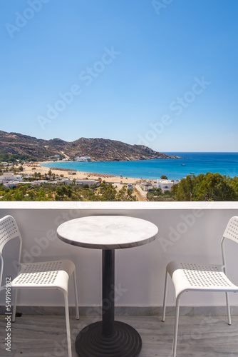 Amazing view from a balcony with chairs and a table overlooking the famous Mylopotas beach in Ios Greece