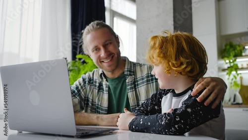 Young father and boy talk by video call with happy smiles photo