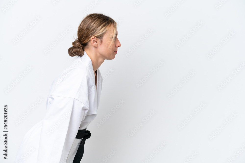 Young caucasian woman isolated on white background doing karate and saluting Young caucasian woman isolated on white background doing karate and saluting