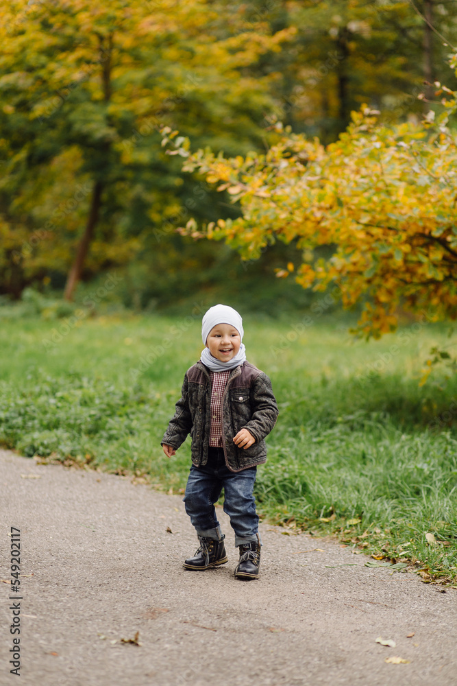 Fototapeta premium Mom and son walking and having fun together in the autumn park.