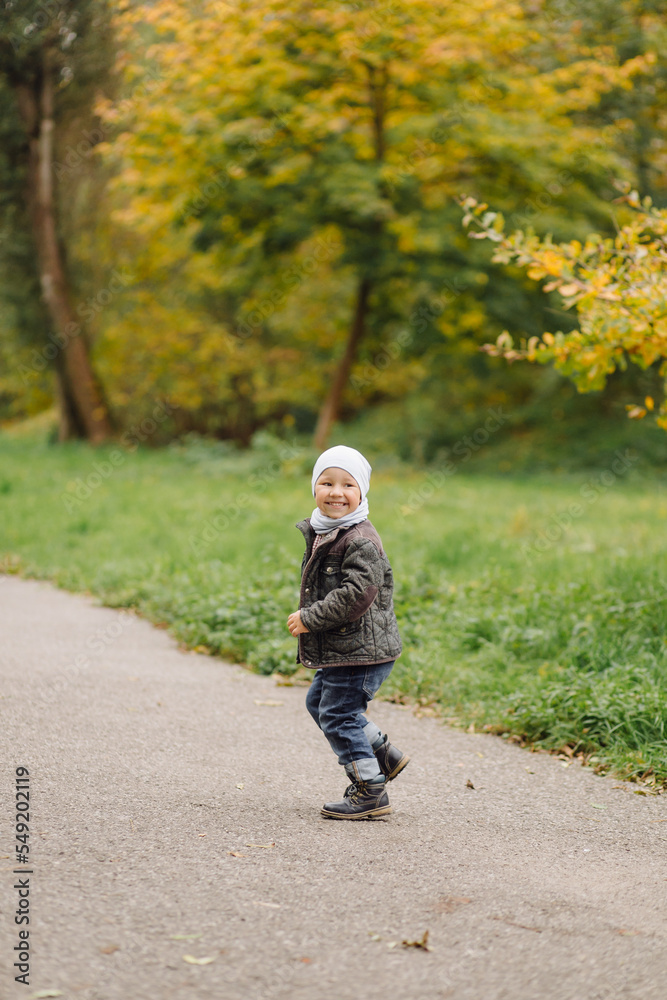 Mom and son walking and having fun together in the autumn park.