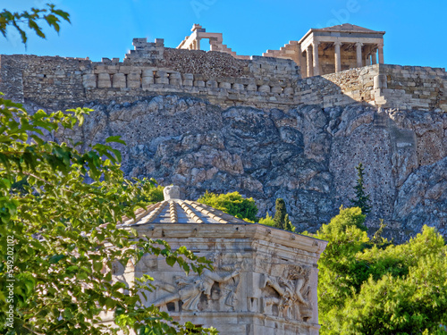 The Erechtheion ancient temple on acropolis hill, and scorch of the Wind's Tower in the Roman forum. A beautiful, sunny day in Athens, Greece. photo