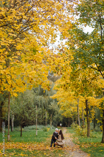 Mom and son walking and having fun together in the autumn park.