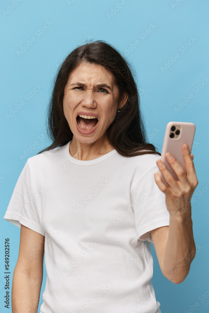 portrait of an emotional, screaming, surprised woman in a white t-shirt on a light blue background. Horizontal studio photo