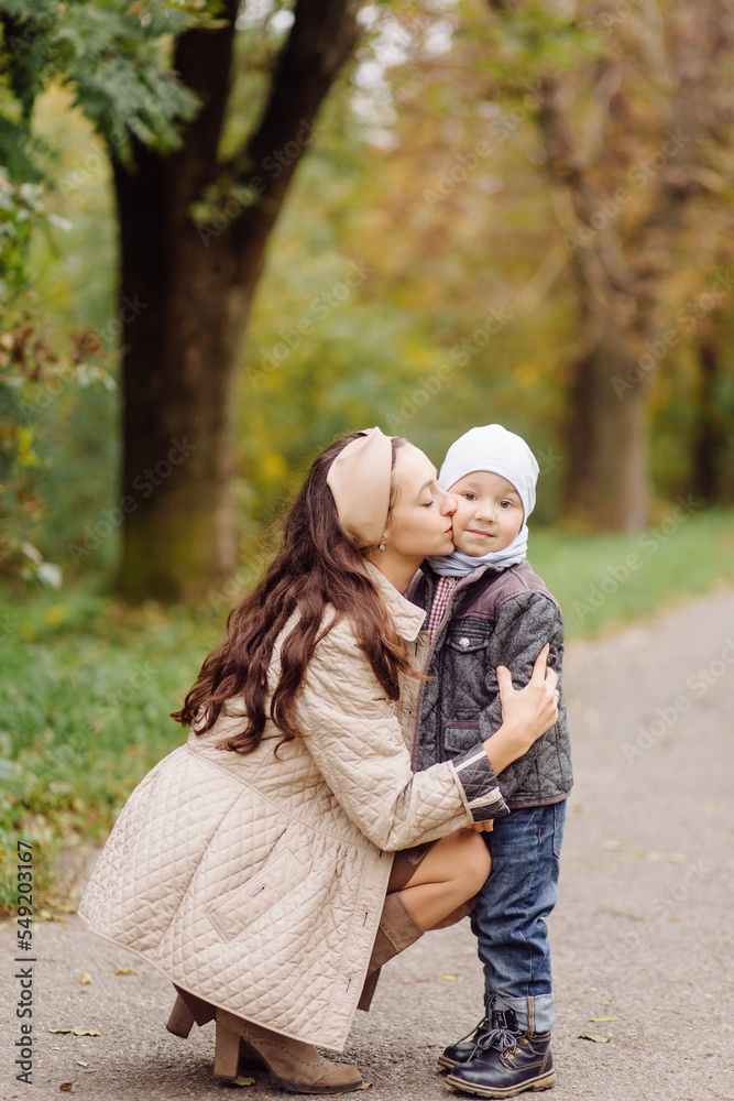 Mom and son walking and having fun together in the autumn park. Mom and son walking and having fun together in the autumn park.