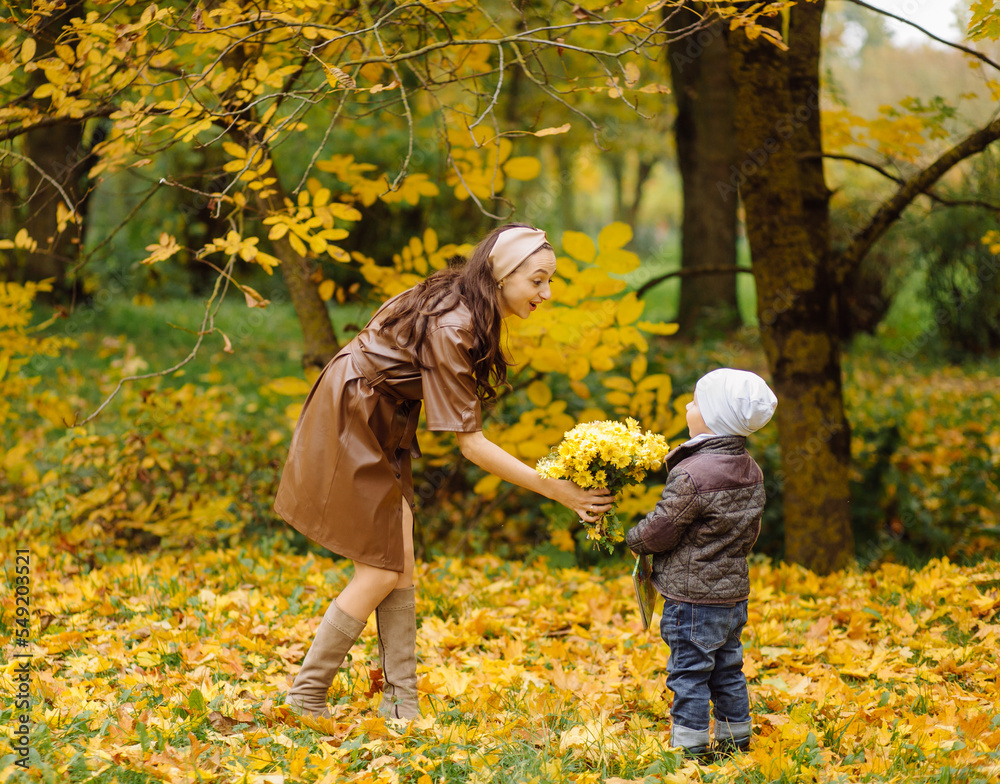 Mom and son walking and having fun together in the autumn park. Mom and son walking and having fun together in the autumn park.