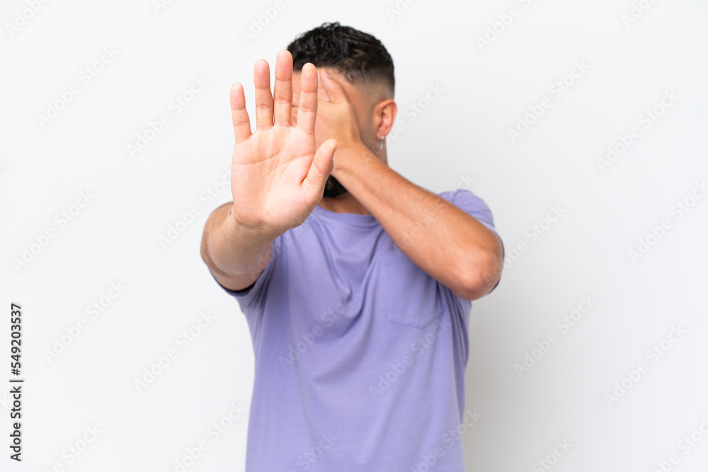 Young Arab handsome man isolated on white background making stop gesture and covering face Young Arab handsome man isolated on white background making stop gesture and covering face