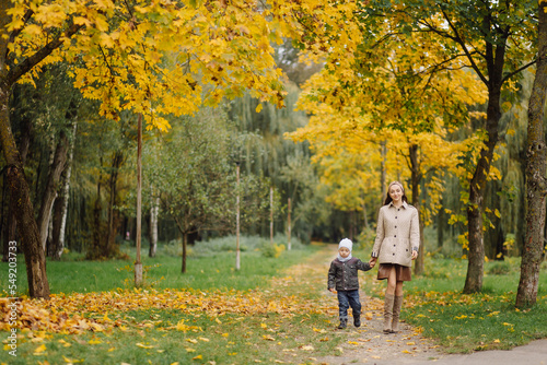 Mom and son walking and having fun together in the autumn park. © andriyyavor