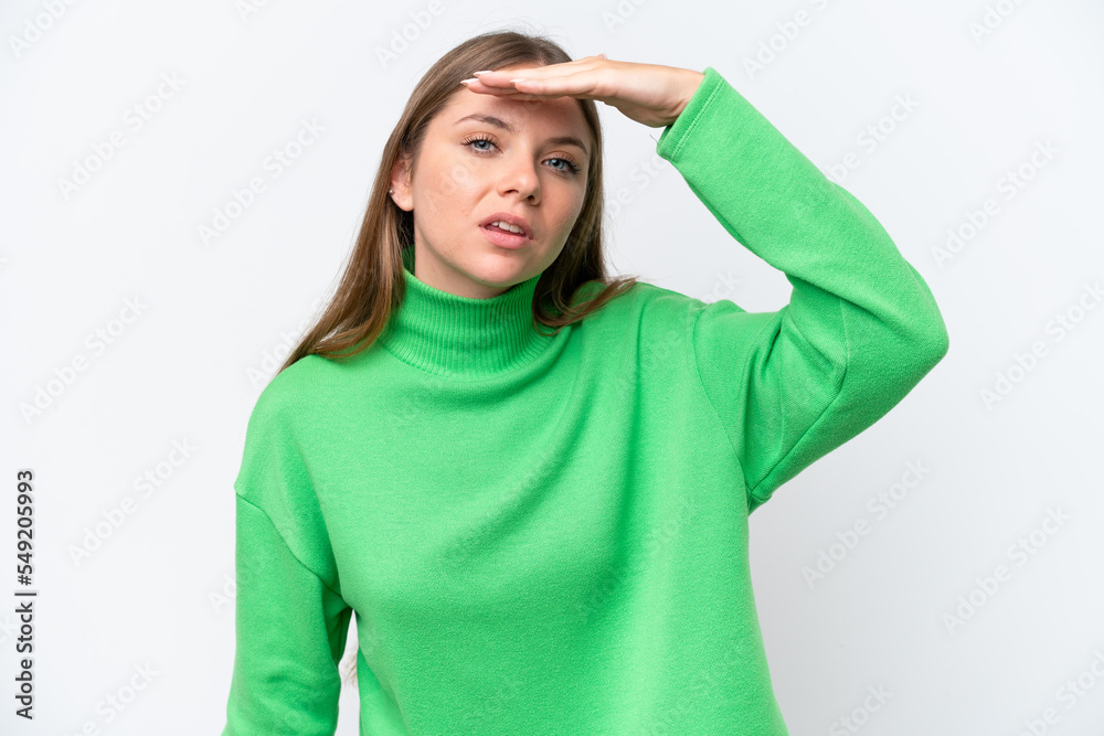 Young beautiful blonde woman isolated on white background looking far away with hand to look something Young beautiful blonde woman isolated on white background looking far away with hand to look something