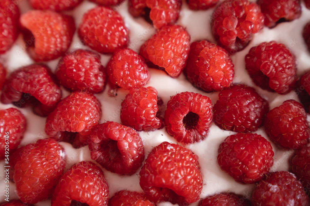 Pastry bakery. Red raspberriey paced in the cream of a delicious cake in process. Close up straight from top. Pastry bakery. Red raspberriey paced in the cream of a delicious cake in process. Close up straight from top.
