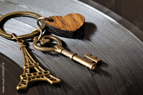 key with a keychain in the shape of a heart and an eiffel tower on a black background
