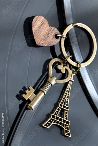 key with a keychain in the shape of a heart and an eiffel tower on a black background