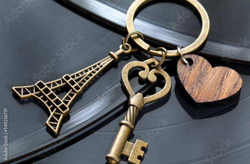key with a keychain in the shape of a heart and an eiffel tower on a black background