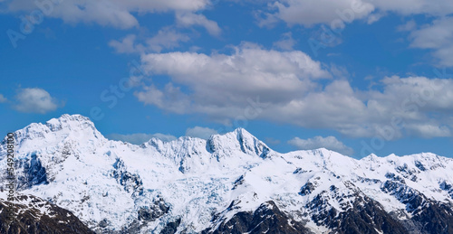 The top mountain view with alpine as snow-capped mount peaks in Swiss Mountain alps against the blue sky background
