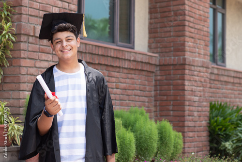 Young indian graduated boy holding his graduation degree convocation ceremony. multiracial student graduate posing. photo