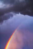 Rays of the sun breaking through the stormy sky, forming a marvelous rainbow