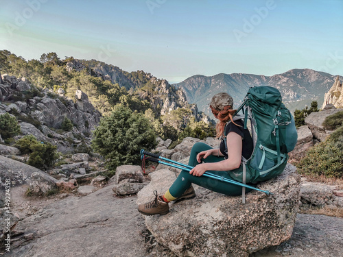 Woman hiking the long distance hike in Corsica called the GR20. A long hike with a heavy backpack. Hiking for two weeks with the most incredible views over the mountains. 