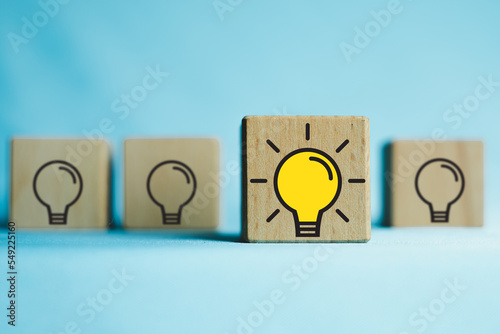 Creative thinking ideas and innovation,New ideas,Education Concept.,Selective focus on wooden cube with light bulb icon over blue background with copyspace for put text or logo.