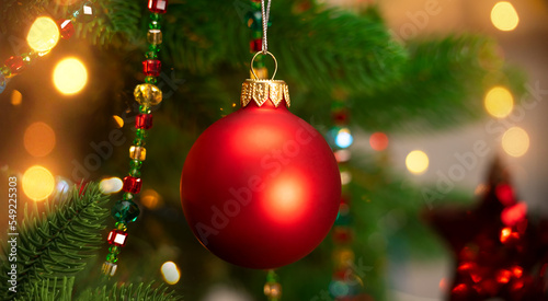 Red ball of Christmas tree on background of garland. Christmas New Year