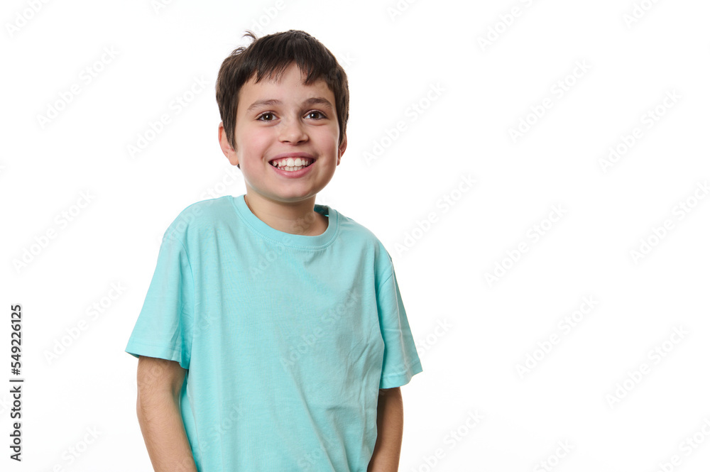 Emotional portrait of Caucasian cheerful teenage boy wearing turquoise t-shirt, smiling a beautiful toothy smile looking at camera, isolated on white background. Copy space for your promotional text Emotional portrait of Caucasian cheerful teenage boy wearing turquoise t-shirt, smiling a beautiful toothy smile looking at camera, isolated on white background. Copy space for your promotional text