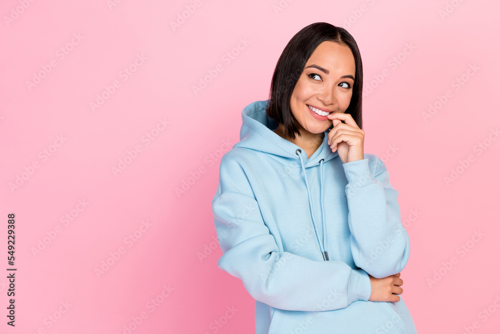 Photo of flirty cute girl dressed blue sweatshirt finger lips looking empty space isolated pink color background Photo of flirty cute girl dressed blue sweatshirt finger lips looking empty space isolated pink color background
