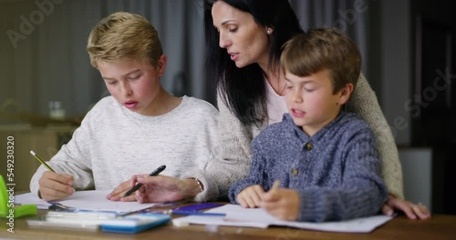 Mother help boys, with homework and for learning to assist with studying or education. Mama, sons and homeschool for teaching, child development or students writing in books, talking or reading notes photo