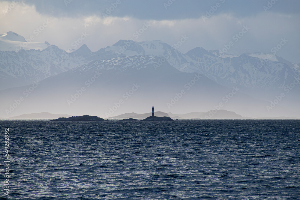 The Andres Mountains in the background with the silhouette of the Les Eclaireurs Lighthouse.  View from the back of the boat with the Ocean in the Foreground. 