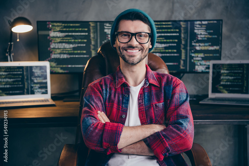 Photo of good mood happy coder dressed hat glasses smiling arms folded indoors workplace workstation loft photo