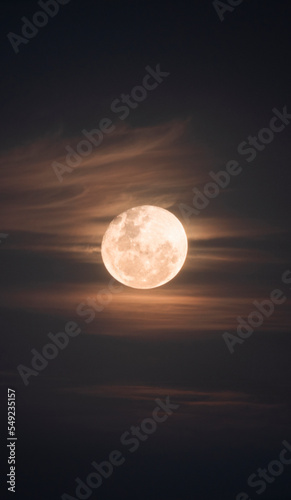 yellow full moon in night sky with clouds