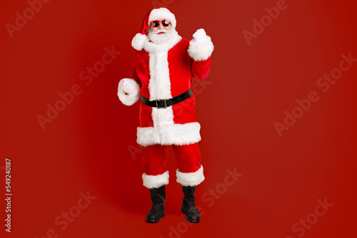 Full length body size view of his he nice funny cheerful cheery white-haired Santa St Nicholas having fun wearing winter warm look outfit isolated bright vivid shine vibrant yellow color background