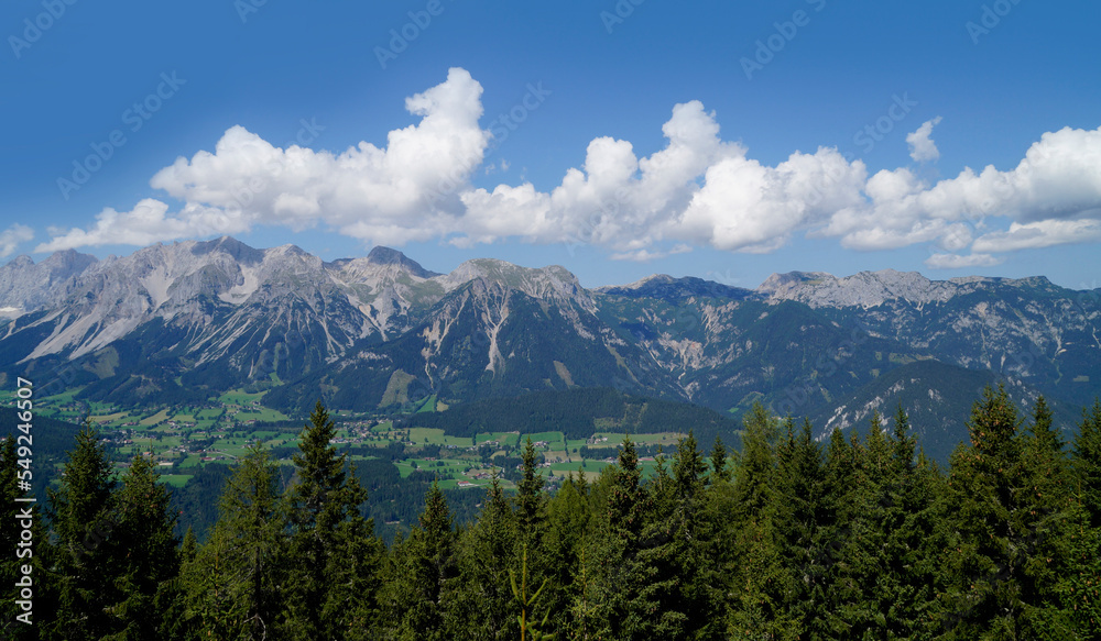 a hiking trail overlooking the beautiful alpine landscape with vast green alpine valley in the Austrian Alps of the Schladming-Dachstein region (Steiermark, Austria)