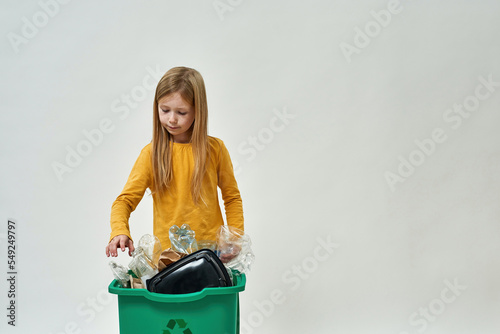 European little girl take garbage from dustbin