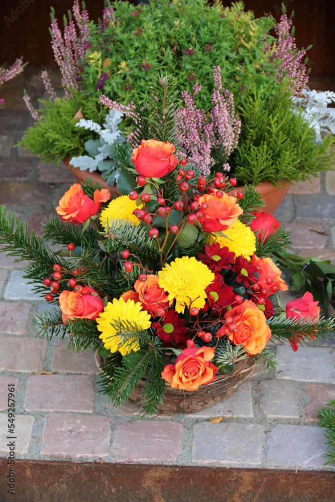 Naklejka premium Gesreck mit Blumen in Geld und Orange auf dem Friedhof im Herbst