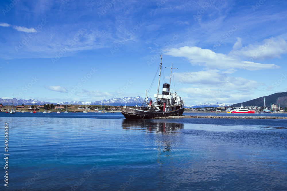 St. Christopher (formerly HMS Justice)  shipwreck with the Ushuaia harbor and Andres Mountains in the background. WWII ear ship now stands as a monument to all ships lost in the region. 