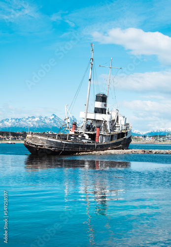 St. Christopher (formerly HMS Justice) shipwreck with the Ushuaia harbor and Andres Mountains in the background. WWII ear ship now stands as a monument to all ships lost in the region. 