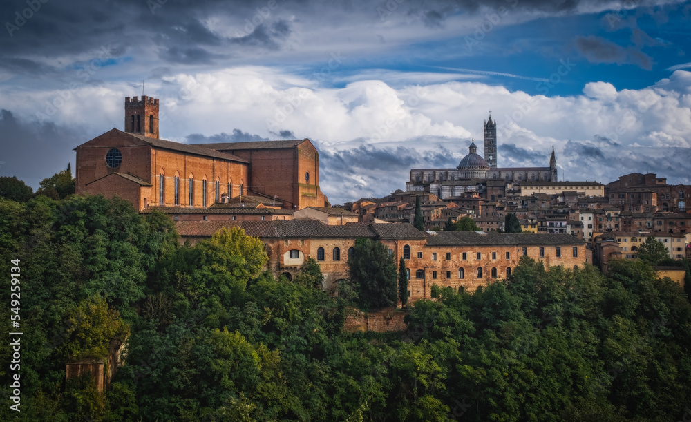 Beautiful panoramic view of the historic city of Siena at daytime with an amazing cloudscape on an idyllic autumn evening, Tuscany, Italy. October 2022