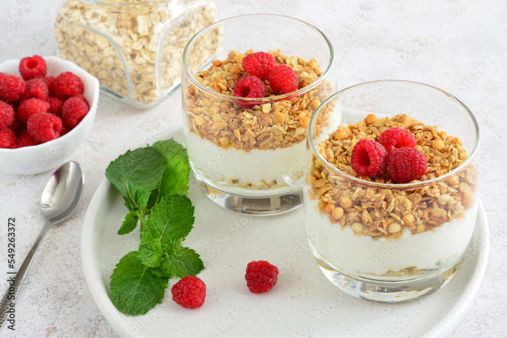 dessert with raspberry, oatmeal and yoghurt in drinking glass decorated with mint leaves dessert with raspberry, oatmeal and yoghurt in drinking glass decorated with mint leaves