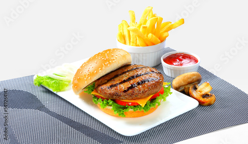 A delicious grilled Angus burger with cheese, lettuce, and tomato on a sesame seed bun. photo