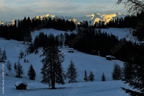 Vor der Nacht auf den winterlichen Armentara Wiesen am  Heiligkreuzkofel in den Dolomiten mit dem schneebedeckten Alpen -Hauptkamm im Hintergrund photo