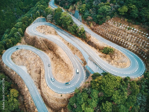 Aerial view of a curvy road from a drone with passing cars. Unzen, Shimabara, Japan. photo