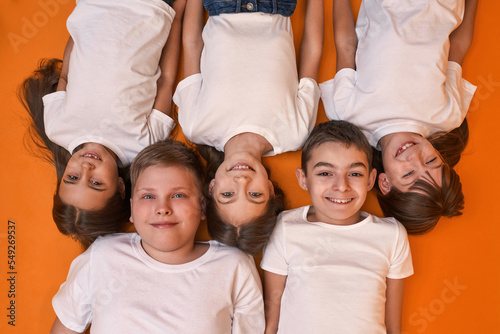 Cropped top view of five children look at camera