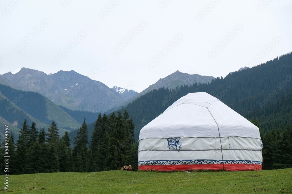 Yurt camp in Karakol Mountains, Tien Shan Mountains, Kyrgyzstan, Central Asia. Traditional nomad's yurt on green mountain meadow in summer. 