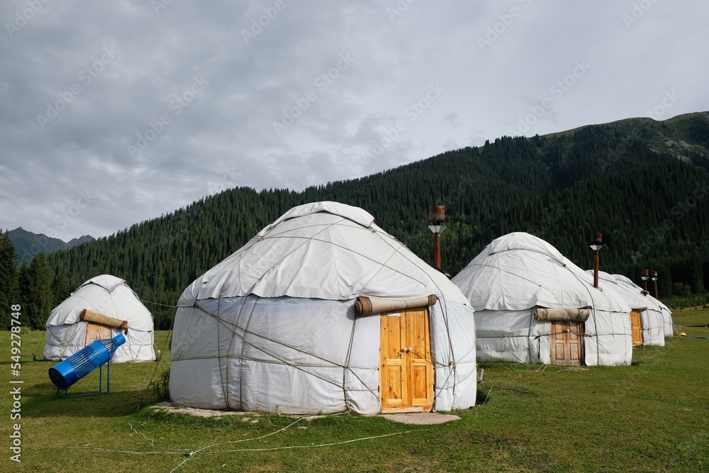 Yurt camp in Karakol Mountains, Tien Shan Mountains, Kyrgyzstan, Central Asia. Traditional nomad's yurts on green mountain meadow in summer. 