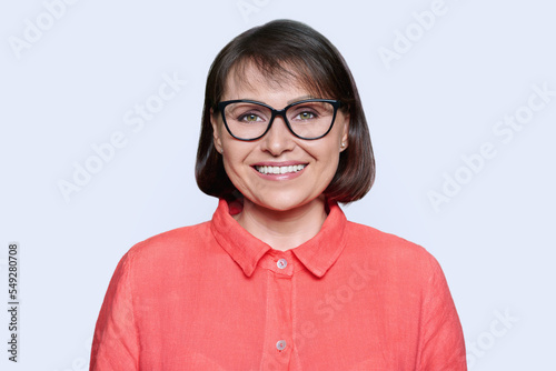 Portrait of woman 45 years old looking at camera on white background