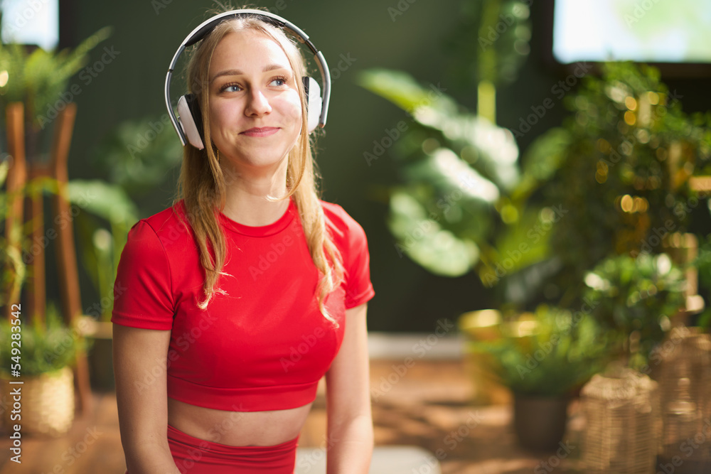 modern female in red fitness clothes in modern green house modern female in red fitness clothes in modern green house