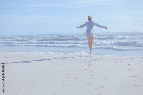 Seen from behind woman at beach rejoicing