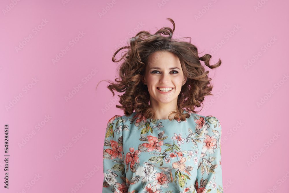 happy trendy woman in floral dress jumping on pink