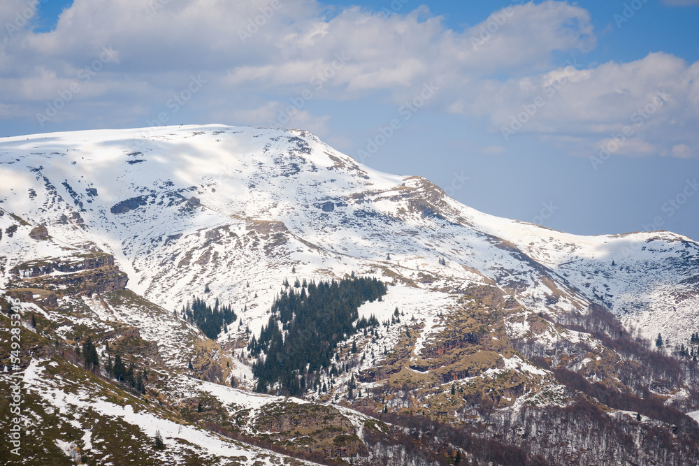 View of a beautiful Kopren summit and plateau, covered by snow, rocky landscape and pine trees on the cliffs